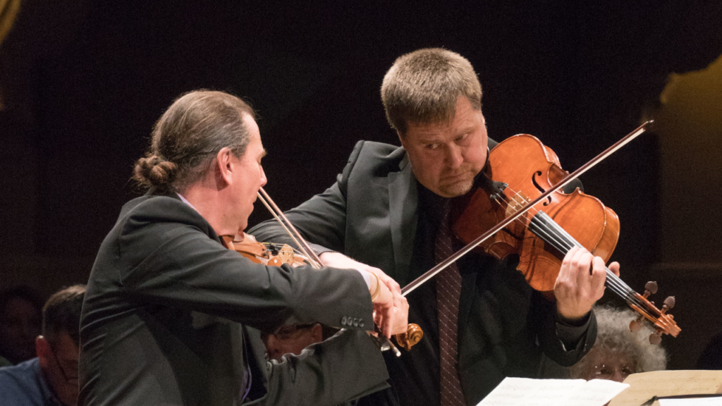 Rohan Gregory and Peter Sulski playing while looking at each other