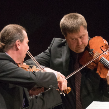 Rohan Gregory and Peter Sulski playing while looking at each other
